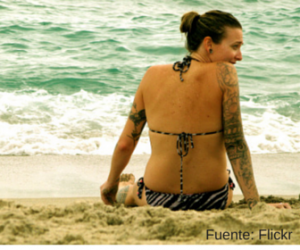 Mujer con tatuaje en la playa